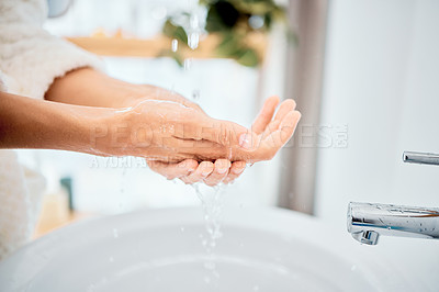 Buy stock photo Shot of a woman washing her hands in her bathroom