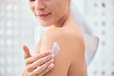 Buy stock photo Shot of a woman applying moisturiser to her arms and shoulders