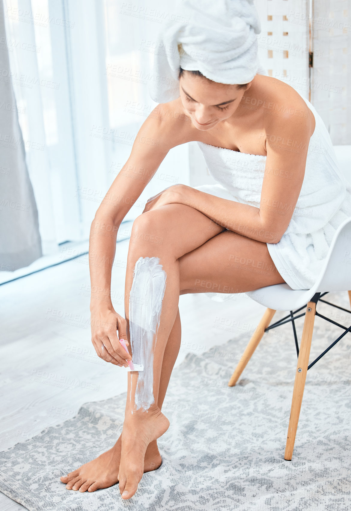 Buy stock photo Shot of a woman shaving her legs in her bathroom