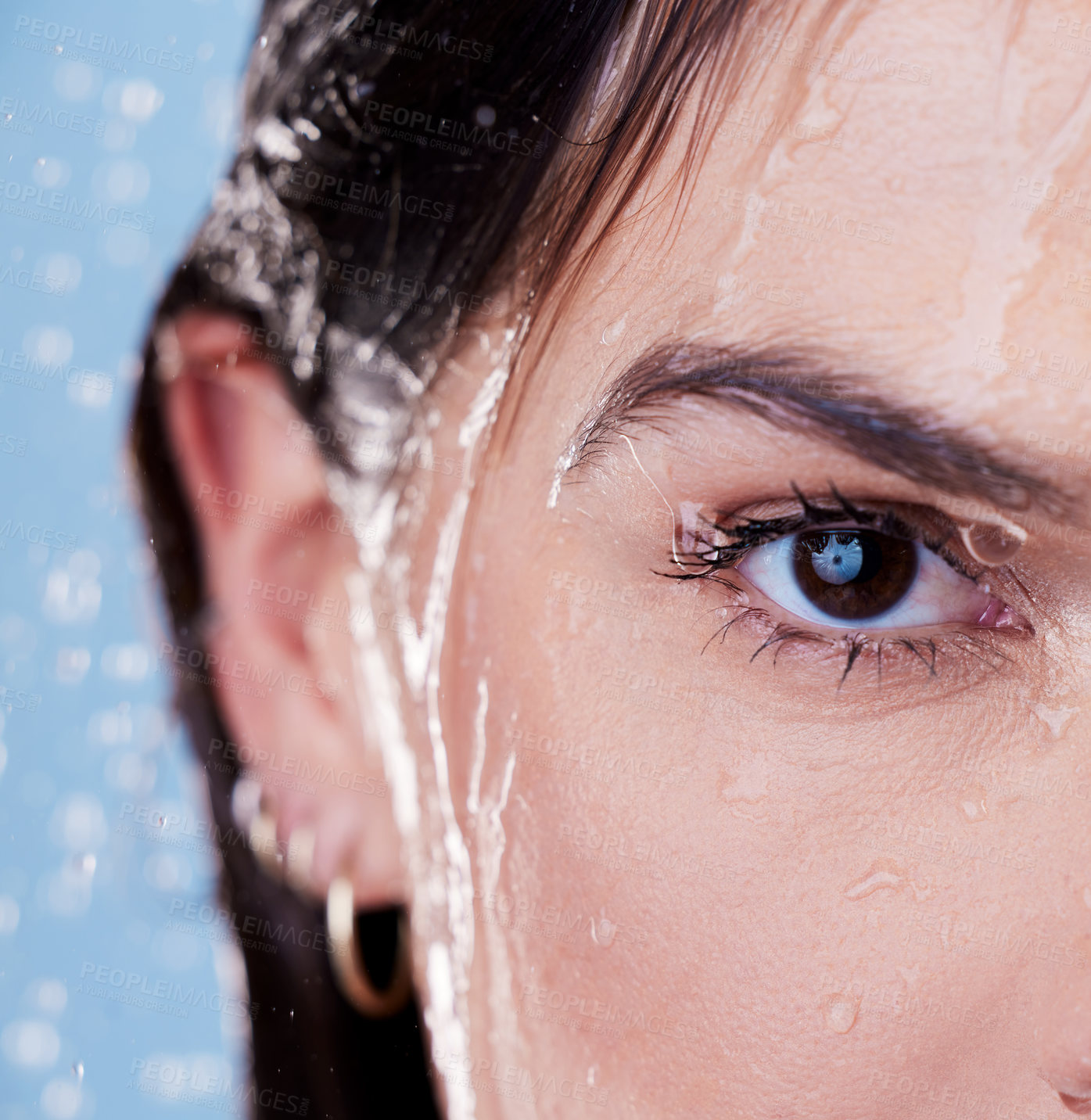 Buy stock photo Woman, half face and shower for cleaning in studio, washing and grooming for skincare on blue background. Female person, water and liquid for cosmetics or treatment and hydration, beauty and skin