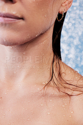 Buy stock photo Studio shot of an unrecognisable woman taking a shower against a blue background