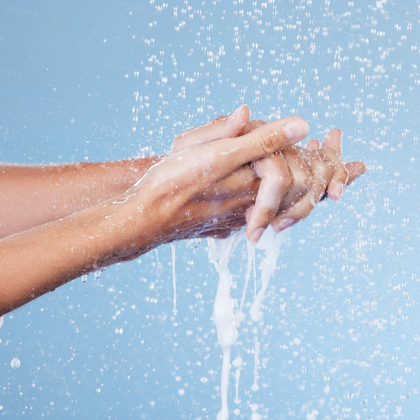 Buy stock photo Studio shot of an unrecognisable woman holding her hands under running water against a blue background