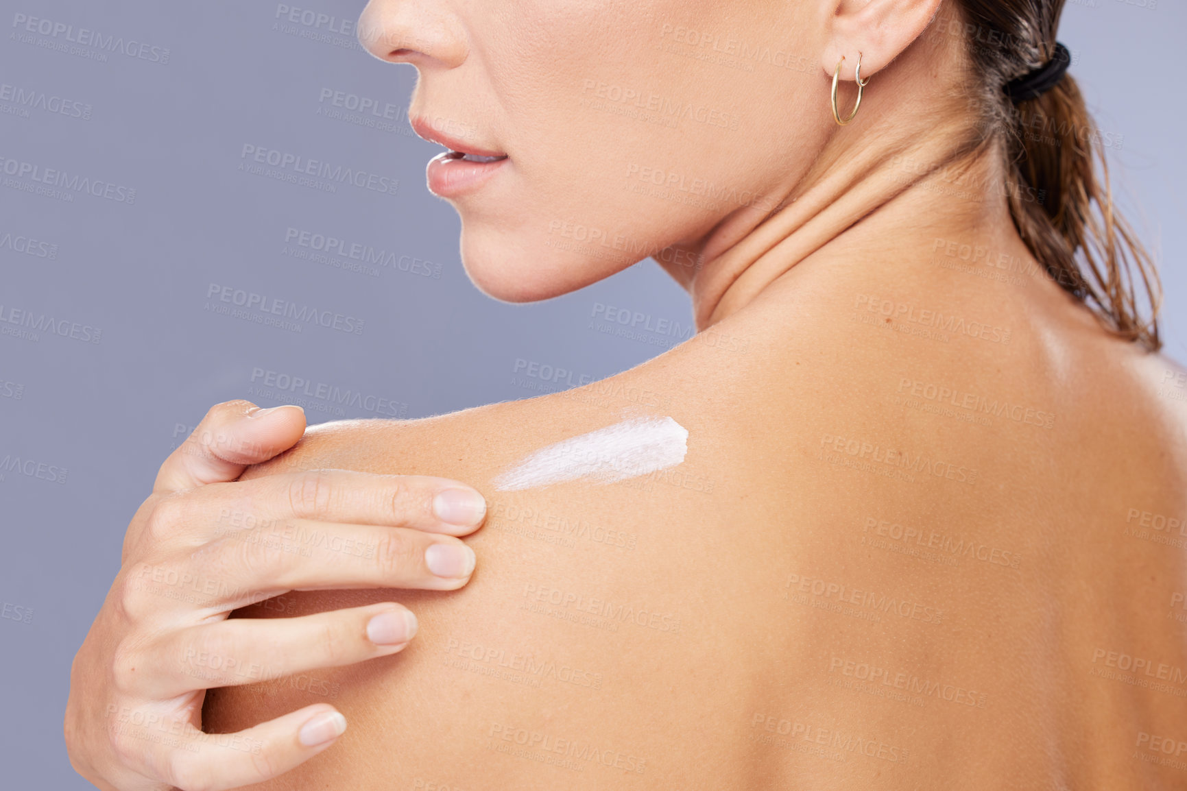 Buy stock photo Woman, shoulder and cream in studio for skincare, ointment and spf or cosmetics on blue background. Person, lotion and pamper for dermatology, grooming and moisturizer for hydration or skin treatment