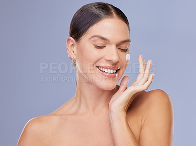 Buy stock photo Happy woman, face cream and beauty product application in studio for wellness, dermatology or collagen on purple background. Smile, sunscreen and girl model with spf, lotion or facial acne treatment