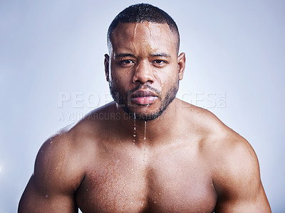 Buy stock photo Studio shot of a handsome young man washing his face against a blue background