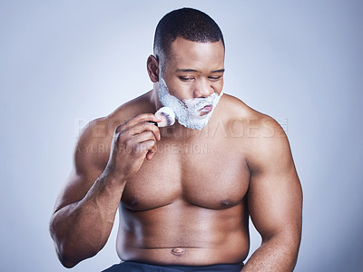 Buy stock photo Black man, brush and apply shaving cream in studio, beauty and cosmetics routine for hair removal. Person, lotion and hygiene or facial treatment for skincare, cleaning and tool on blue background