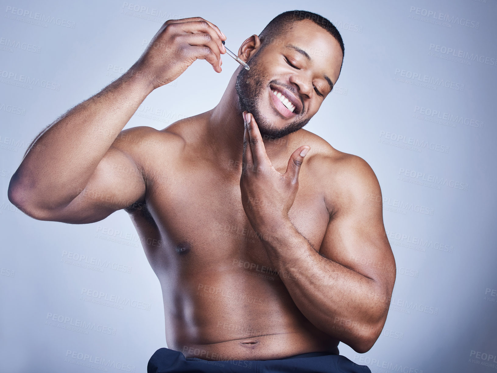Buy stock photo Black man, dropper and apply facial oil in studio, hydration and treatment or cosmetics on blue background. Male person, pipette and liquid for dermatology, grooming and confident for moisture glow