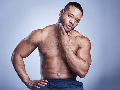 Buy stock photo Studio shot of a handsome young man feeling his skin against a blue background