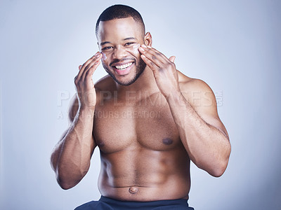 Buy stock photo Black man, apply lotion and studio portrait for skincare, ointment and cosmetics on blue background. Person, cream and facial for dermatology, grooming and moisturizer for hydration or skin treatment