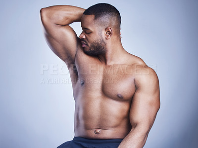 Buy stock photo Studio shot of a handsome young man smelling his armpit against a blue background