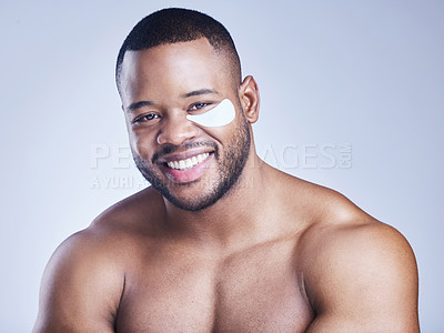 Buy stock photo Studio shot of a handsome young man wearing an under eye patch against a blue background
