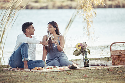 Buy stock photo Man, woman and date with picnic, wine and romance for love or relationship anniversary. Couple, nature and lake with alcohol, happiness and summer passion with bouquet and flowers for celebration