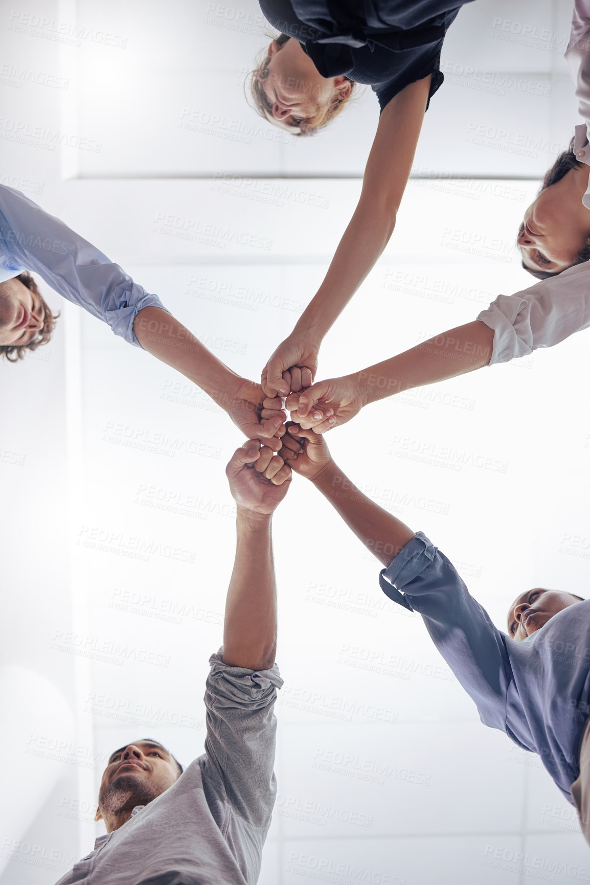 Buy stock photo Circle, business people and fist bump for teamwork, below and motivation in workplace, diversity and solidarity. Businessman, women and team building with hands, support and synergy in modern office