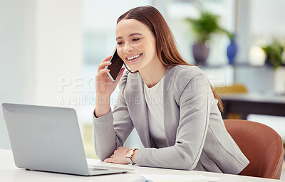 Buy stock photo Shot of a young woman using her phone and laptop in a office