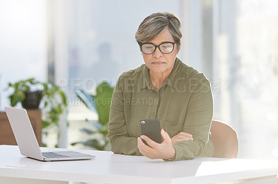 Buy stock photo Mature, business and woman with smartphone in office, laptop and communication for businesspeople. Web, and internet search on technology for information, company and typing online for networking