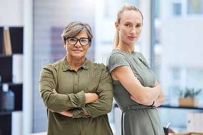Buy stock photo Shot of two businesswomen standing together in the office with their arms folded