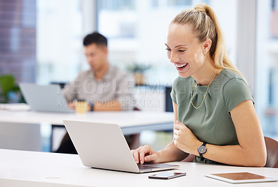 Buy stock photo Shot of an attractive young businesswoman sitting in the office and using her laptop
