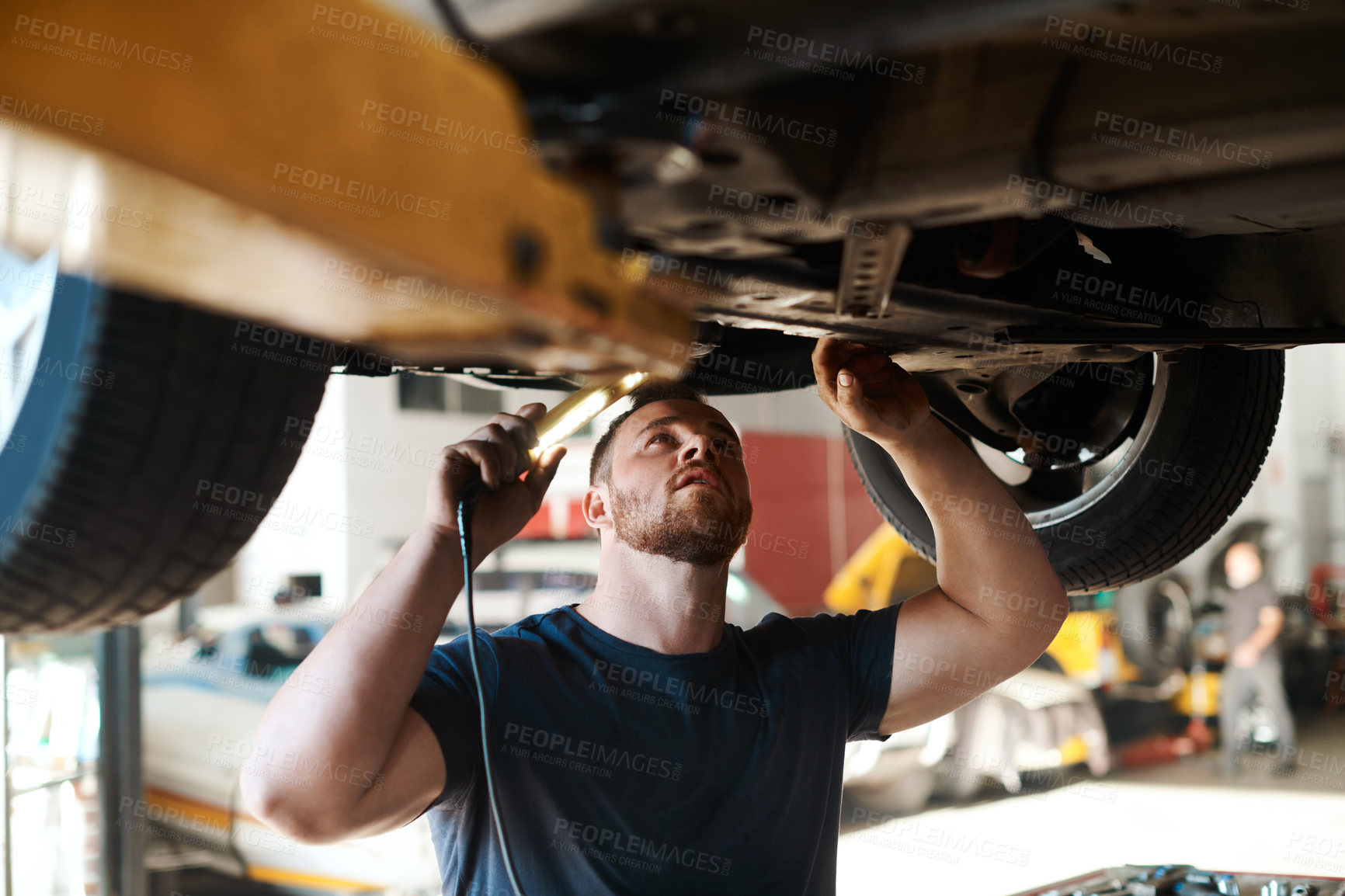 Buy stock photo Torch, inspection and mechanic with vehicle in workshop for service, maintenance or repair for safety. Light, auto engineering and male industrial worker checking bottom of car for oil leak in garage