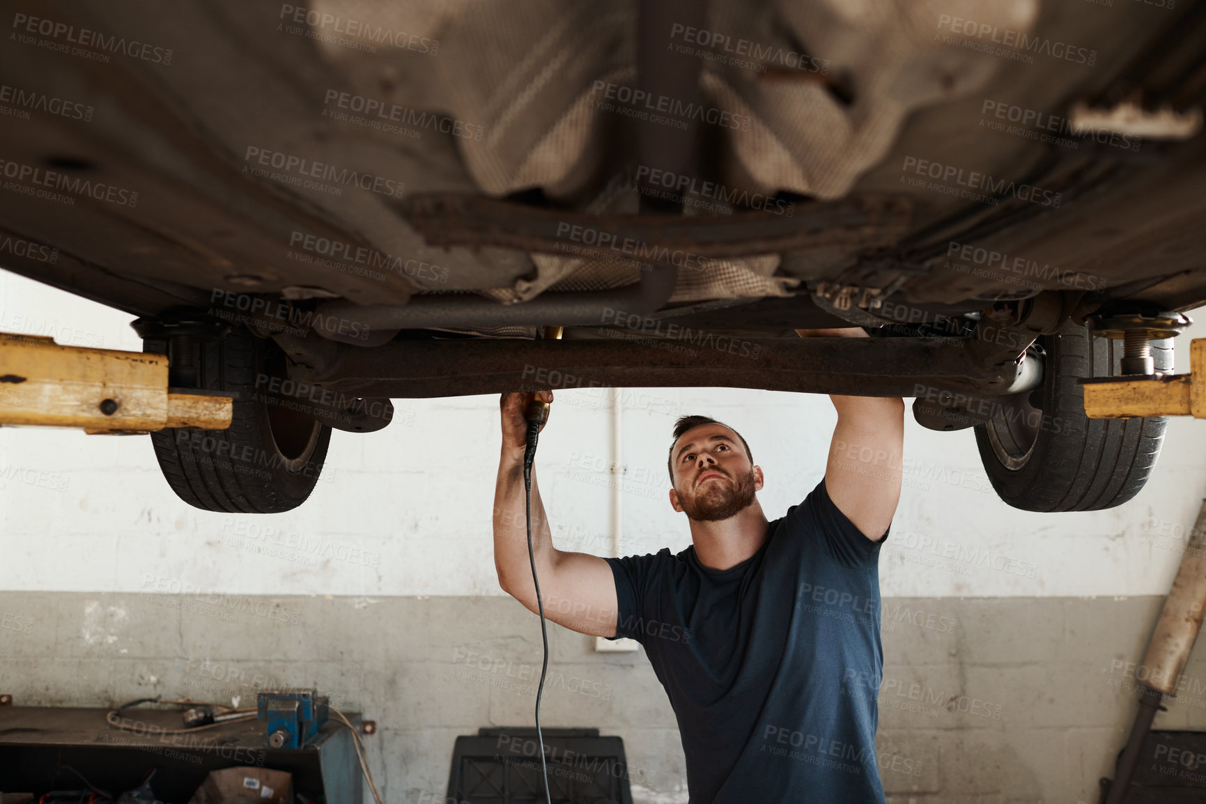Buy stock photo Torch, repair and mechanic with car in workshop for service, maintenance or inspection for safety. Light, auto engineering and male industrial worker checking bottom of vehicle for oil leak in garage