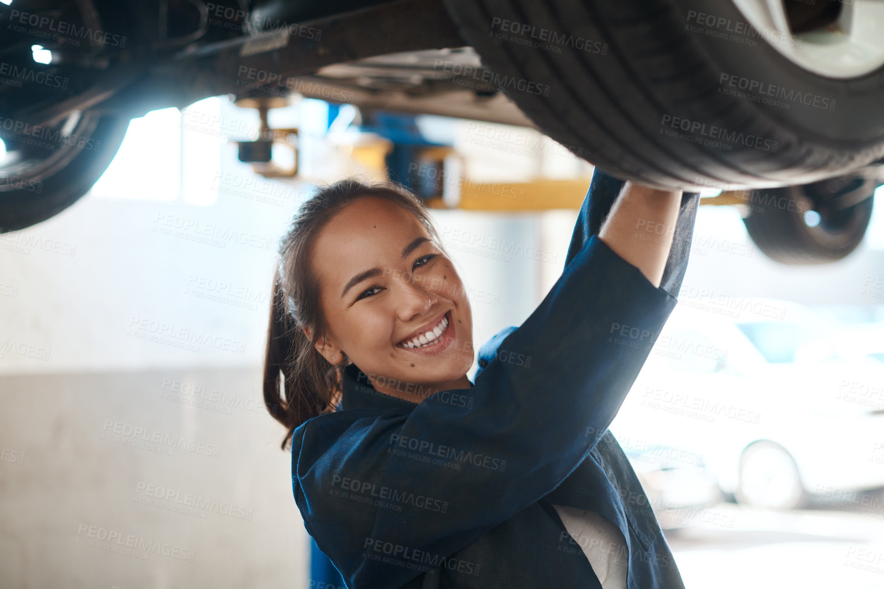 Buy stock photo Female mechanic, check and tool for service with car in garage, inspection or maintenance on wheel. Woman, auto and happiness for problem with motor tyre, technician working or repair on transport