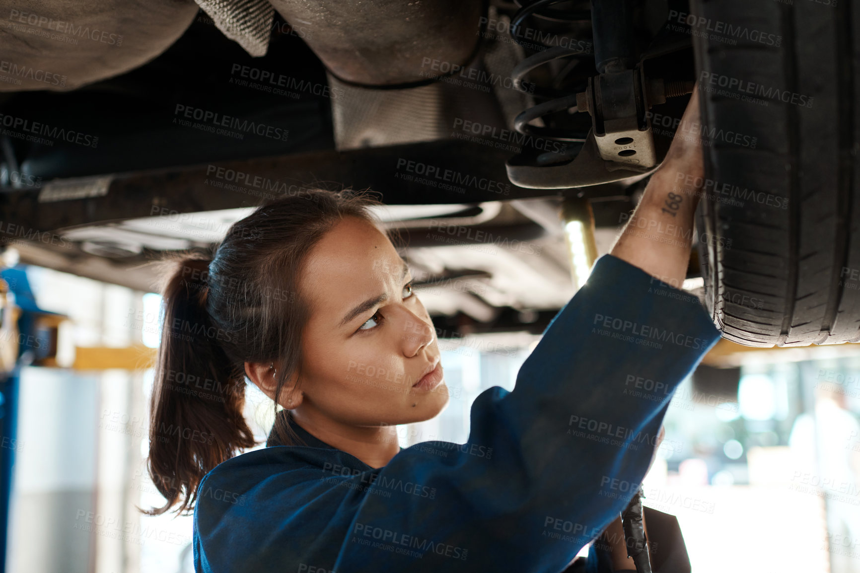 Buy stock photo Female mechanic, check and tool for maintenance with car in garage, inspection or service for wheel. Woman, auto and happiness for problem with motor tyre, technician working or repair on transport