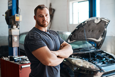 Buy stock photo Shot of a mechanic posing with his arms crossed in an auto repair shop