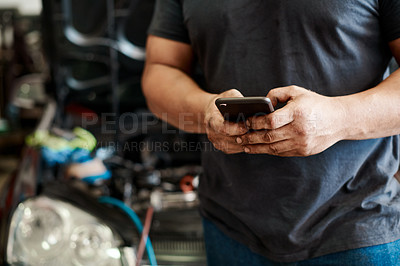 Buy stock photo Phone, hands and mechanic in workshop with car service, maintenance or search for auto insurance. Typing, engine and man in garage with smartphone for inspection, motor repair and quality assurance