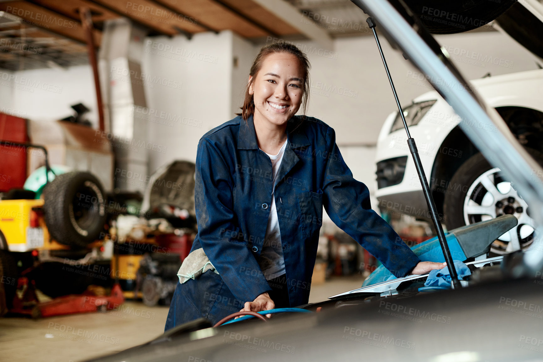 Buy stock photo Car, mechanic and portrait of woman in workshop for maintenance, repair or service of engine. Assessment, auto and expert with smile of happy asian vehicle engineer or technician at inspection garage