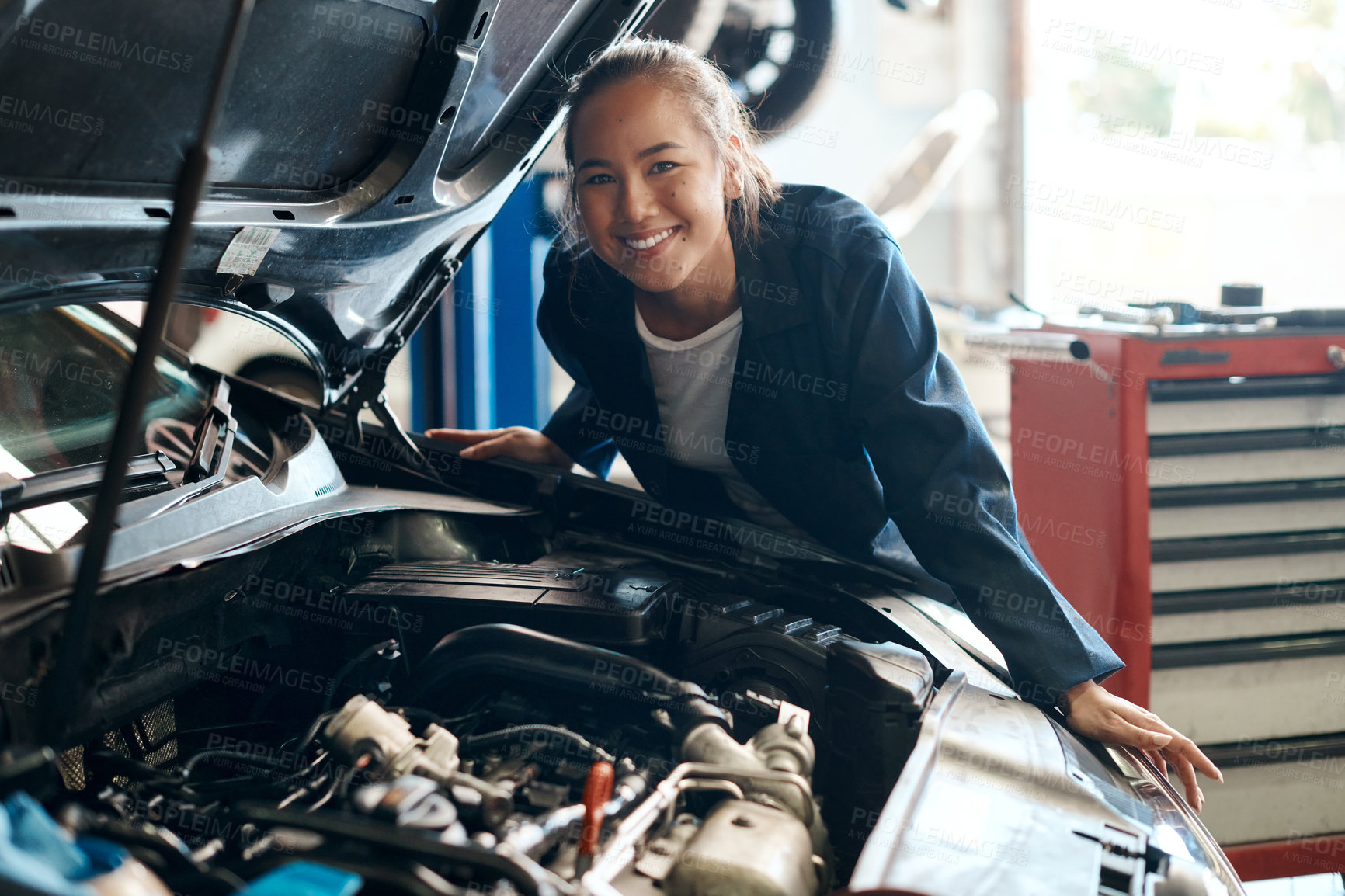 Buy stock photo Woman, portrait and working on engine as mechanic in garage for repair, maintenance and vehicle service. Girl, smile and car as automotive technology in workshop for engineering or motor performance