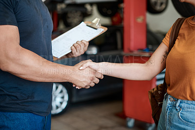 Buy stock photo Shot of a woman shaking hands with a mechanic in an auto repair shop