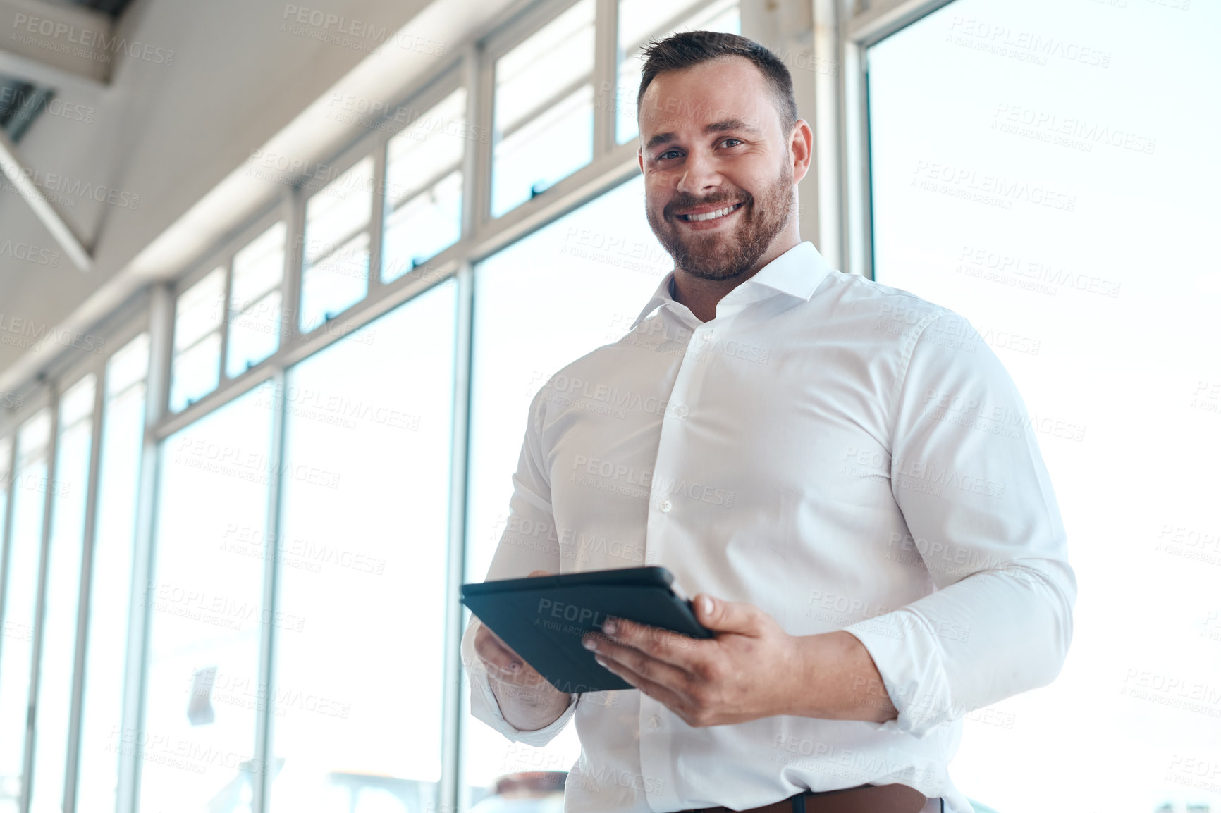 Buy stock photo Shot of a car salesman using his digital tablet