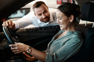 Buy stock photo Shot of a young woman testing out a new car she's about to purchase