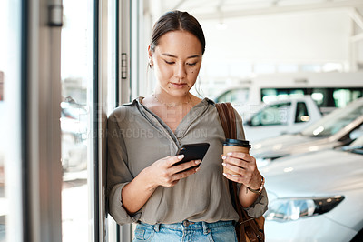 Buy stock photo Cellphone, coffee and female person in a showroom typing a text message or scrolling on social media. Communication, technology and woman browsing on a mobile app with a cellphone at a car dealership