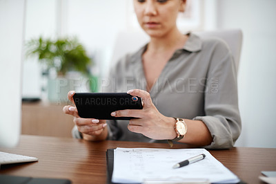 Buy stock photo Shot of a young businesswoman using her smartphone to send text messages