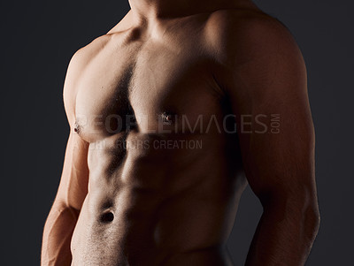 Buy stock photo Cropped shot of an unrecognizable man standing alone in the studio and posing shirtless
