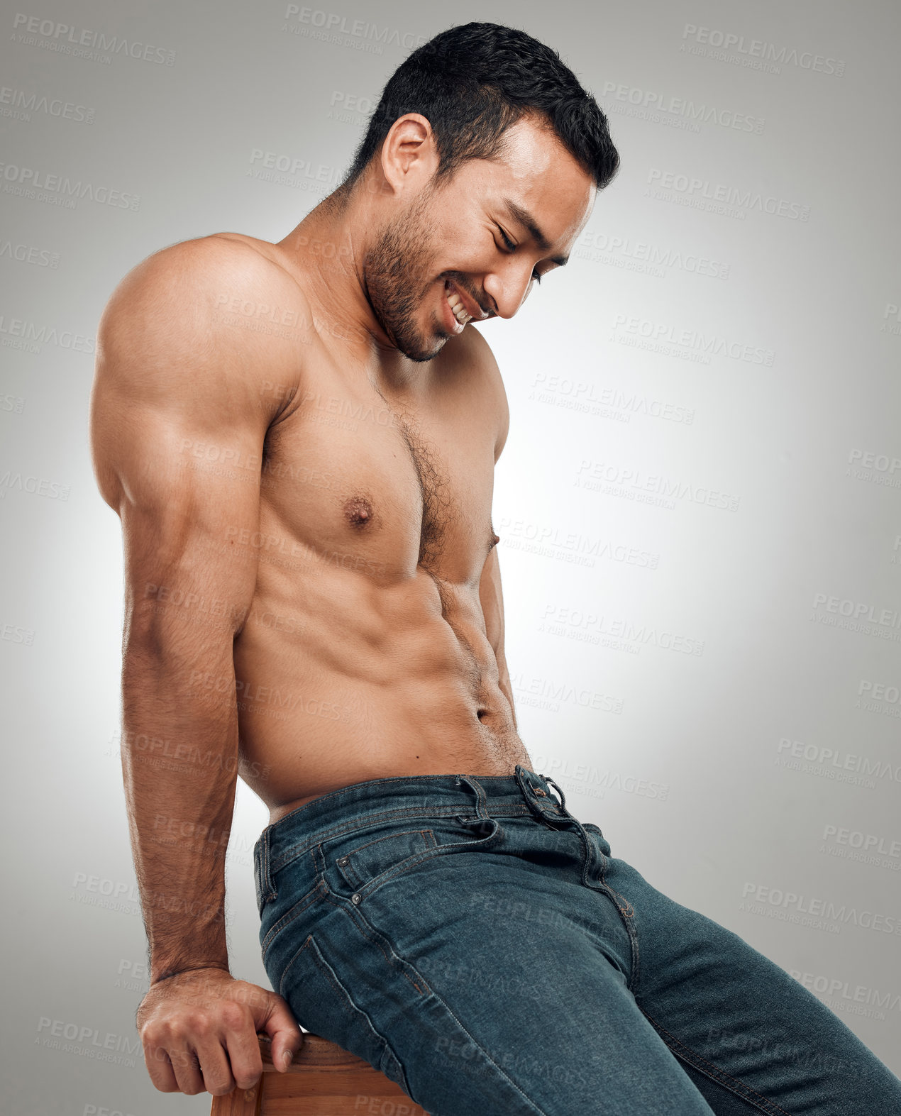 Buy stock photo Man, chair and topless in studio for fitness, wellness and strong abs muscle on gray background. Male person, denim jeans and shirtless for health, bodybuilder and proud of body or workout results