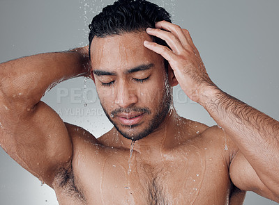 Buy stock photo Shot of a young man washing his hair in the shower against a grey background