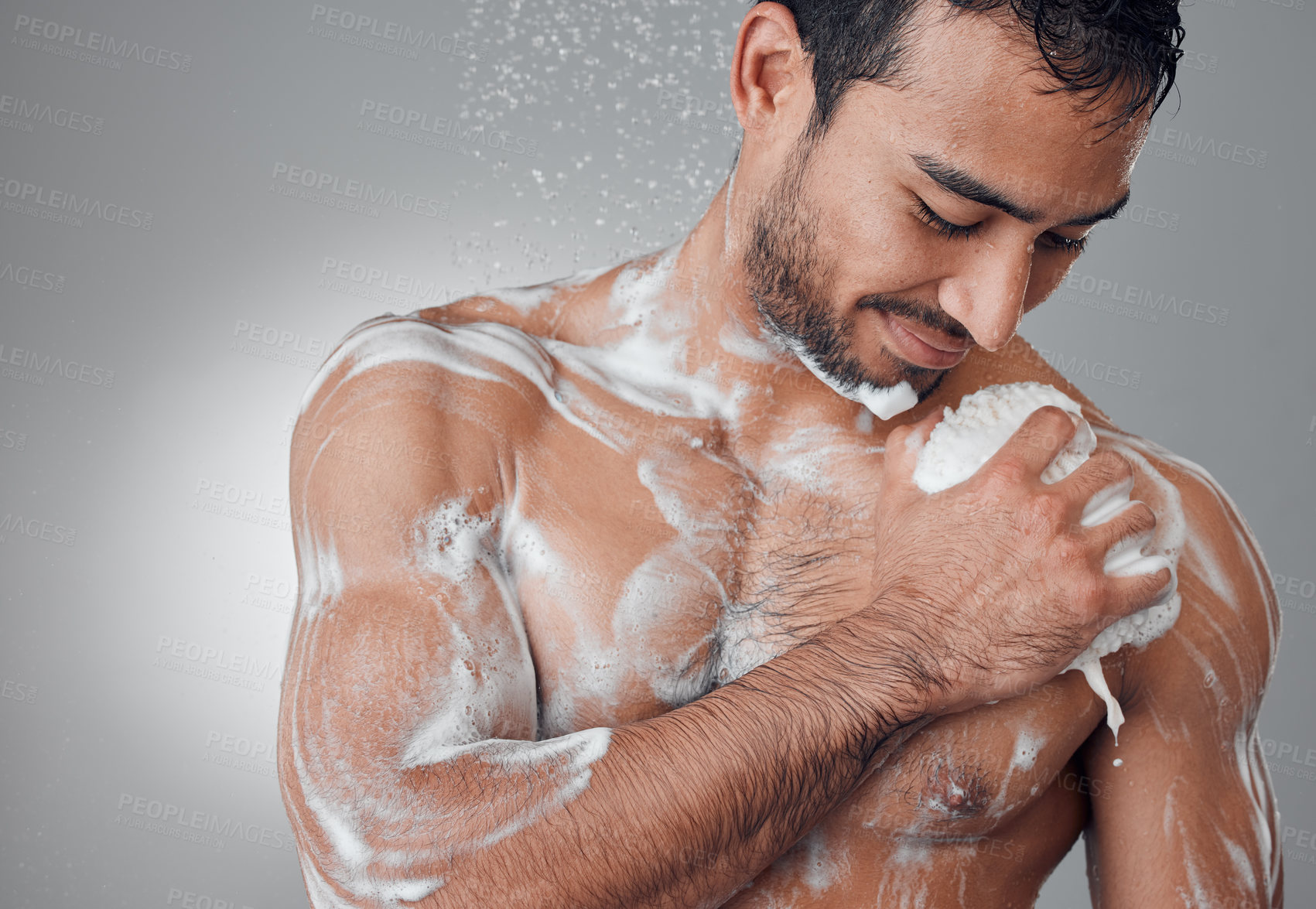 Buy stock photo Shot of a young man taking a shower against a grey background