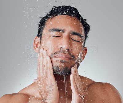 Buy stock photo Shot of a young man taking a shower against a grey background
