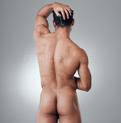 Buy stock photo Shot of a young man taking a shower against a grey background