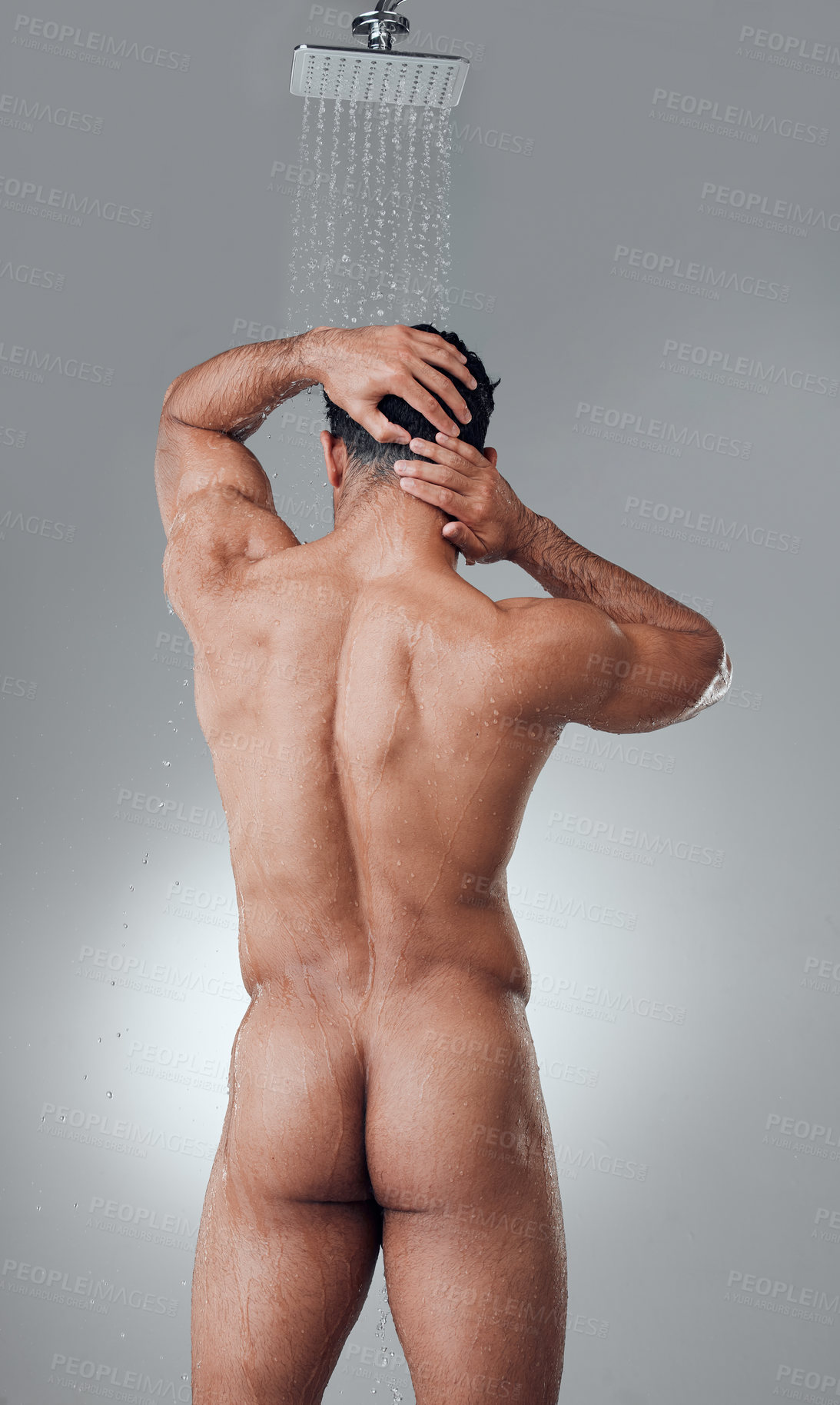 Buy stock photo Shot of a young man taking a shower against a grey background