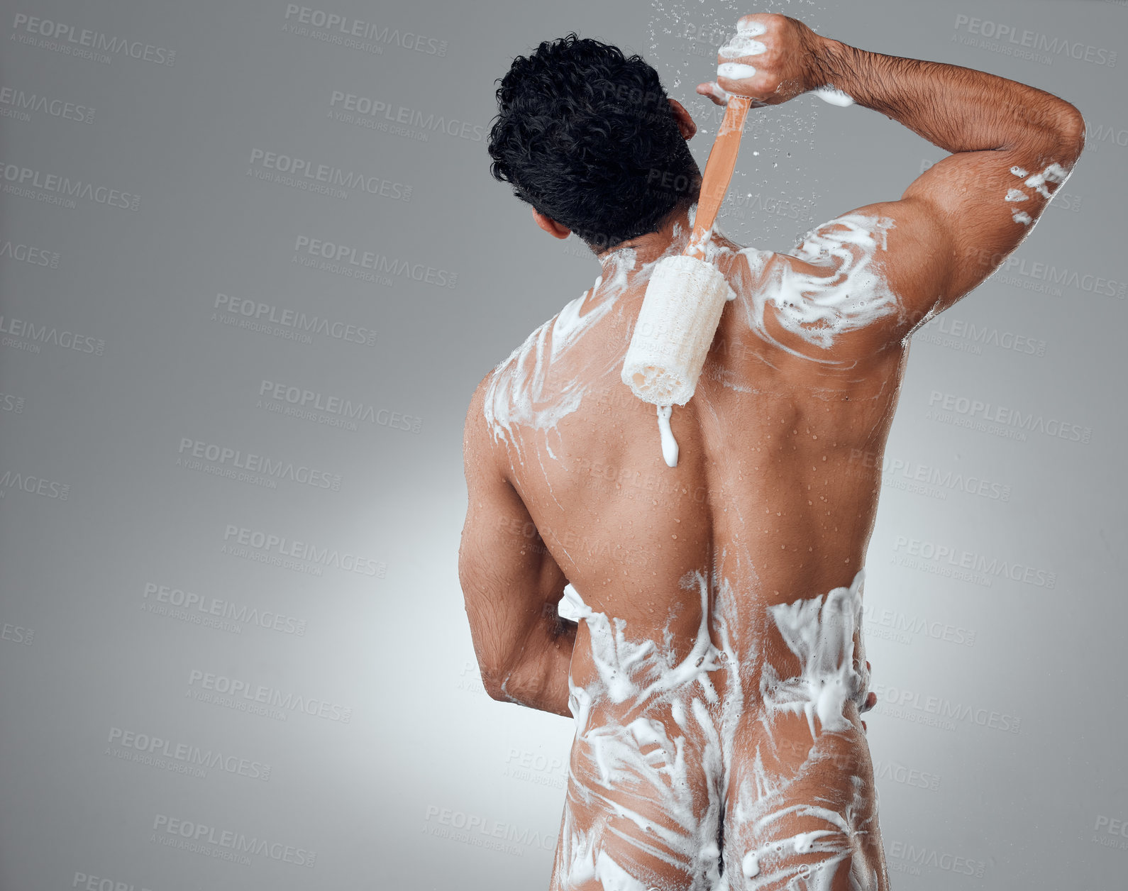 Buy stock photo Shot of a young man taking a shower against a grey background