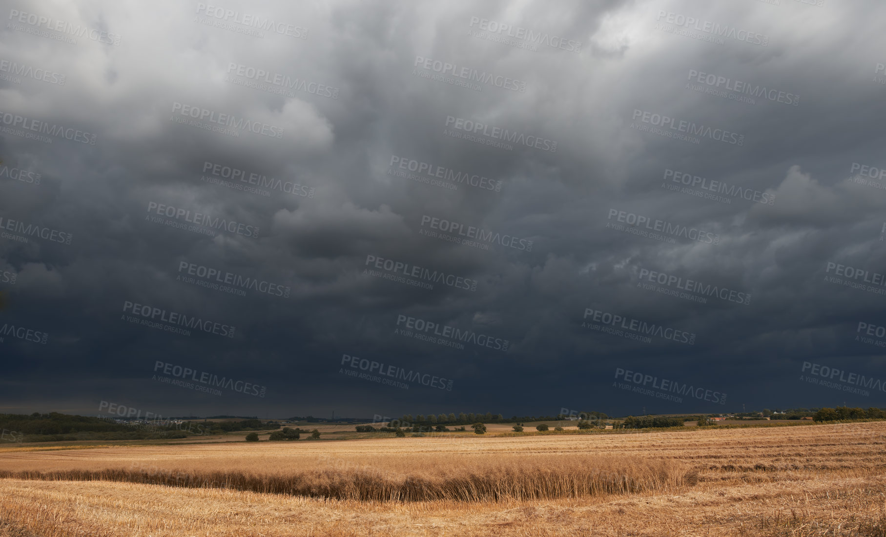 Buy stock photo Landscape view of dark clouds in harvest nature. Grey cloudy sky over dry grassy cold field with autumn colors in the outdoor life. Stormy, overcast weather over a wilderness environment. 