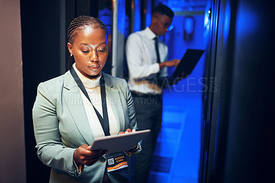 Buy stock photo Shot of a young woman using a digital tablet while working in a server room