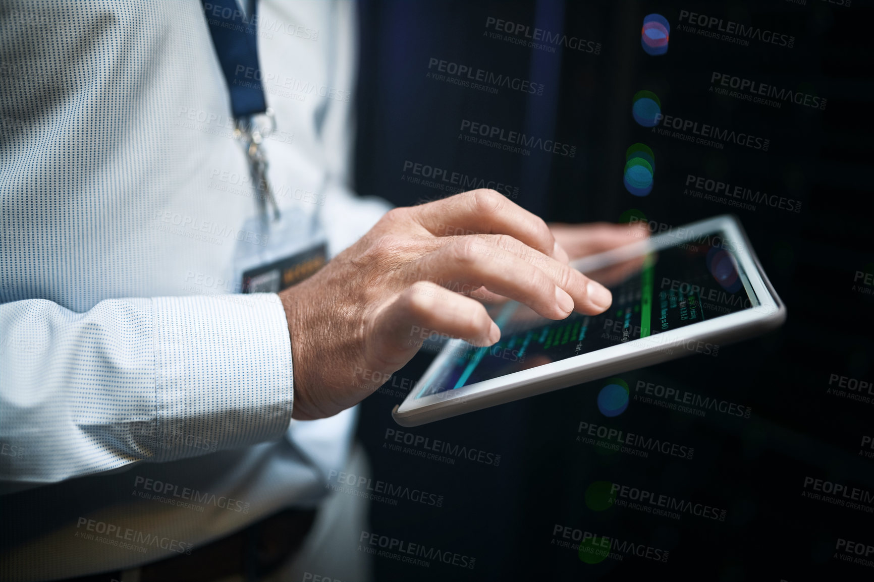 Buy stock photo Closeup shot of an unrecognisable man using a digital tablet while working in a server room