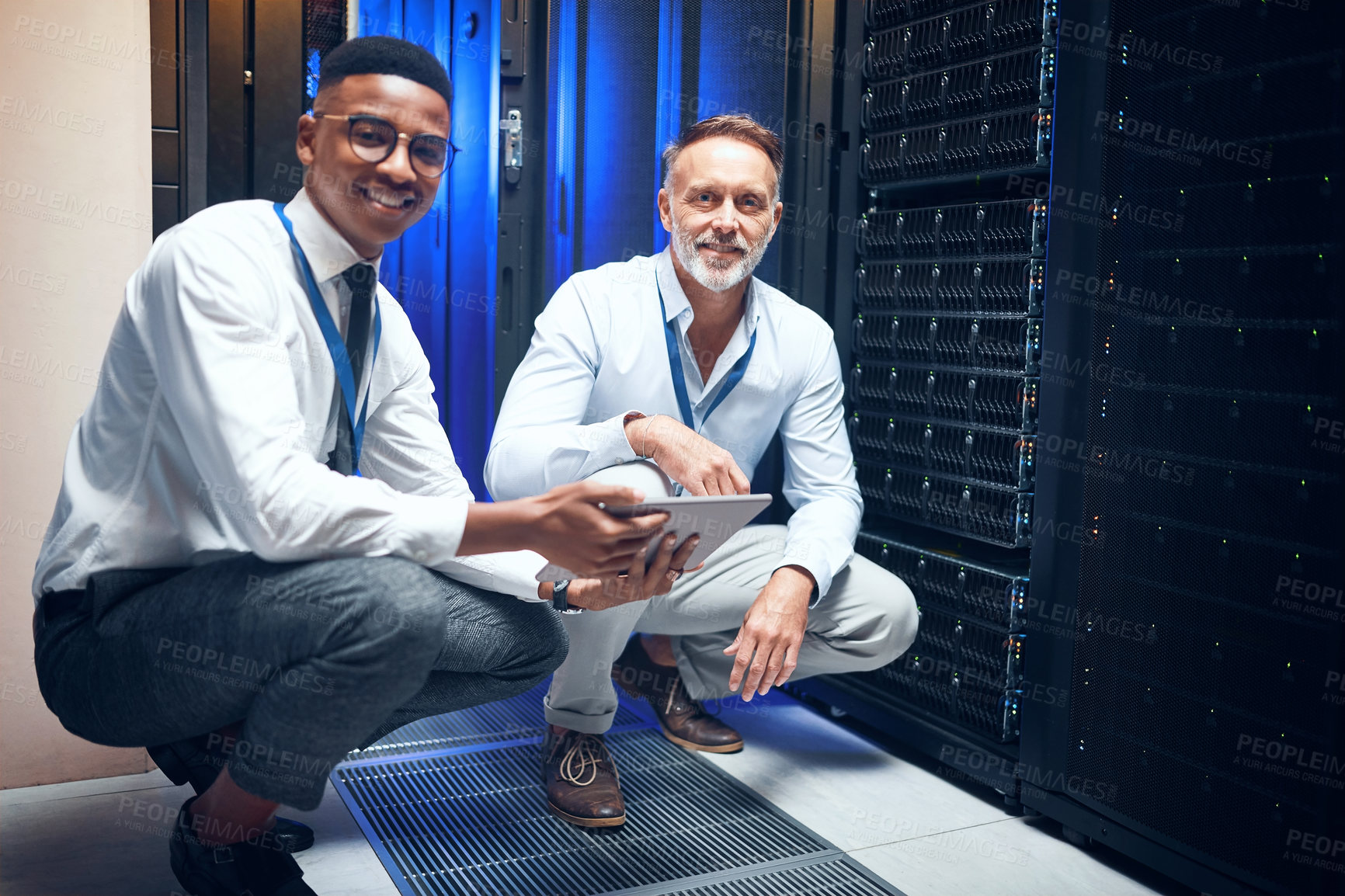 Buy stock photo Portrait of two technicians using a digital tablet while working in a server room