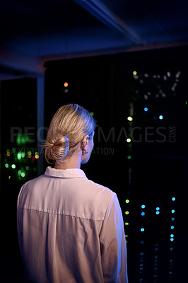 Buy stock photo Rearview shot of a young woman working in a server room