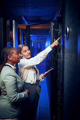 Buy stock photo Shot of two technicians using a digital tablet while working in a server room