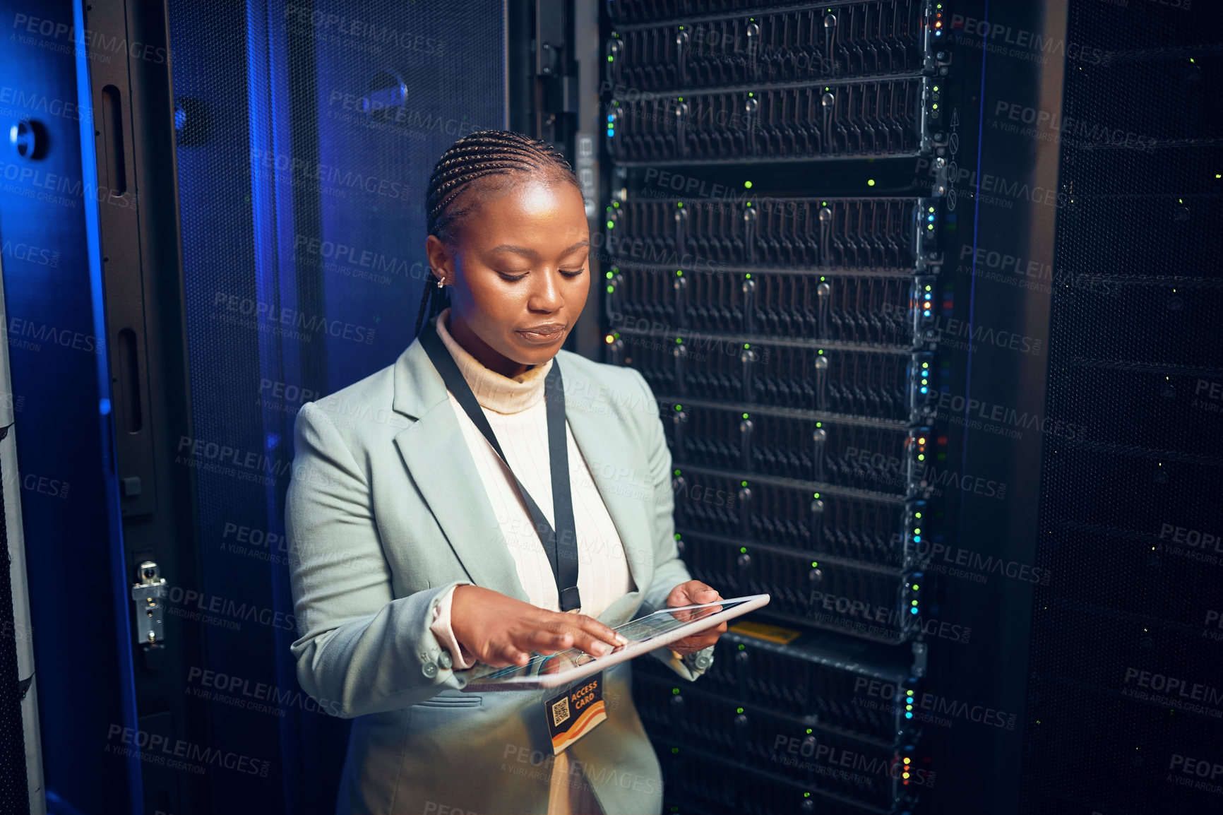 Buy stock photo Shot of a young woman using a digital tablet while working in a server room