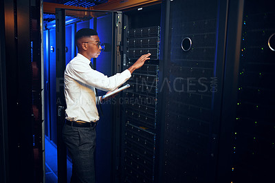 Buy stock photo Shot of a young man using a digital tablet while working in a server room